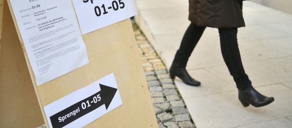 A woman past a sign showing the way to a polling station during the presidential election in Salzburg, Austria on December 4, 2016 - Sputnik International