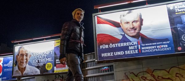 A man walks his dog around a park where Election posters of Austrian Presidential election candidates Norbert Hofer (R),Freedom Party Austria FPOe, and Alexander Van der Bellen (L) are seen in Vienna, Austria on December 3, 2016 - Sputnik International