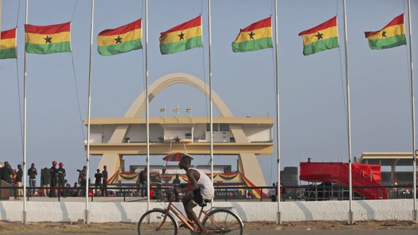 A man rides a bicycle past Ghanian flags flown at half mast to honor late Ghanian President, John Evans Atta Mills at the independence square in Accra, Ghana, Thursday, Aug.9, 2012.  - Sputnik International