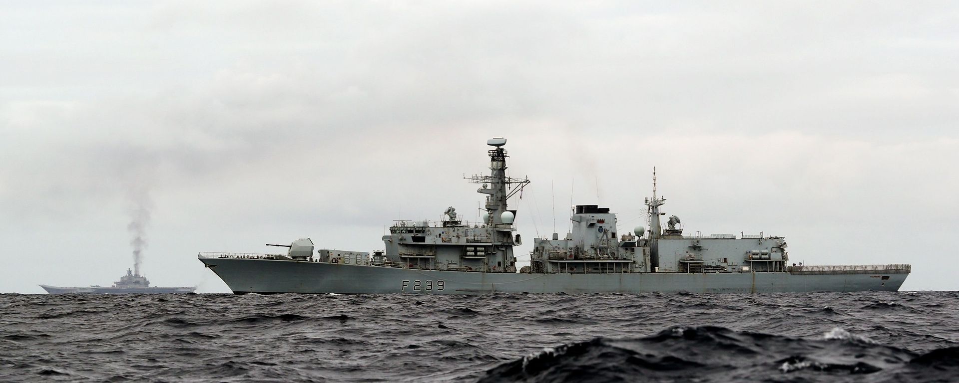 This is a handout photo issued by Britain's Ministry of Defence taken on Wednesday Oct. 19, 2016, of HMS Richmond, foreground, a Type 23 Duke Class frigate, observing aircraft carrier Admiral Kuznetsov, at rear left, which is part of a Russian task group, during transit through the North Sea This is a handout photo issued by Britain's Ministry of Defence taken on Wednesday Oct. 19, 2016, of HMS Richmond, foreground, a Type 23 Duke Class frigate, observing aircraft carrier Admiral Kuznetsov, at rear left, which is part of a Russian task group, during transit through the North Sea - Sputnik International, 1920, 27.09.2021