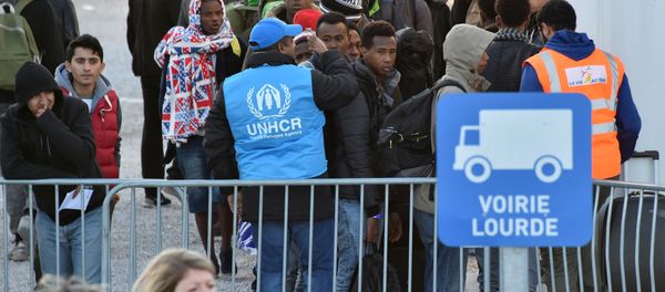 Volonteers of the United Nations High Commissioner for Refugees (UNHCR) agency and La Vie Active association help unaccompanied migrant minors, from the demolished Jungle migrant camp in Calais, to board a bus to travel to reception centres around France on November 2, 2016 in Calais, northern France - Sputnik International