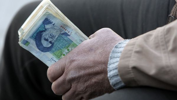 Iranian street money changer holds Iranian banknotes (File) Iranian street money changer holds Iranian banknotes (File) - Sputnik International