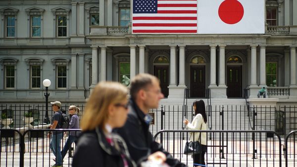 Pedestrians pass infront of US and Japan flags on the Eisenhower Executive Office Building next to the White House on April 27, 2015 in Washington, DC - Sputnik International