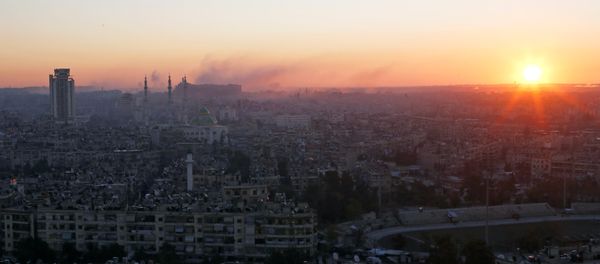 The sun rises while smoke is pictured near Aleppo's historic citadel, as seen from a government-controlled area of Aleppo, Syria December 6, 2016. - Sputnik International