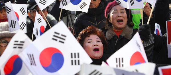 Supporters of South Korean President Park Geun-Hye wave the national flags during a rally against the impeachment of the president outside the ruling Saenuri Party in Seoul on December 6, 2016. - Sputnik International