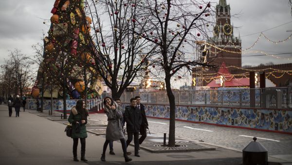 Young tourists enjoy a warm weather walking in Red Square illuminated to mark the upcoming Christmas and New Year celebrations in Moscow, Russia - Sputnik International