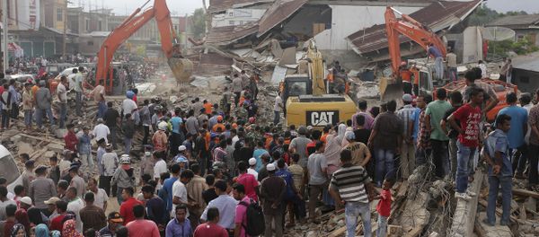 Rescuers use excavators to search for victims under the rubble of collapsed buildings after an earthquake in Pidie Jaya, Aceh province, Indonesia - Sputnik International