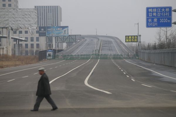 A man walks past the new Yalu Bridge in Dandong. The Chinese side of the bridge is finished, but construction on the Korean side has been halted due to a shortage of funds. A man walks past the new Yalu Bridge in Dandong. The Chinese side of the bridge is finished, but construction on the Korean side has been halted due to a shortage of funds. - Sputnik International