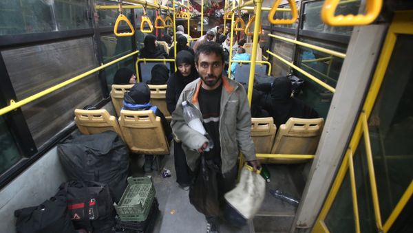 Syrian residents of the Old City of Aleppo stand in a bus at a crossing point during their evacuation to a distinct government-controlled area of the city early on December 7, 2016 Syrian residents of the Old City of Aleppo stand in a bus at a crossing point during their evacuation to a distinct government-controlled area of the city early on December 7, 2016 - Sputnik International