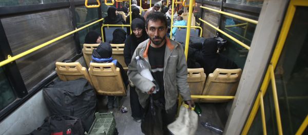 Syrian residents of the Old City of Aleppo stand in a bus at a crossing point during their evacuation to a distinct government-controlled area of the city early on December 7, 2016 - Sputnik International