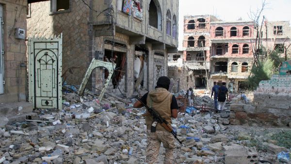 A pro-government fighter walks at the site of recent battles between Houthi fighters and pro-government troops , on the second day of a 48-hour ceasefire in the southwestern city of Taiz, Yemen November 20, 2016 - Sputnik International