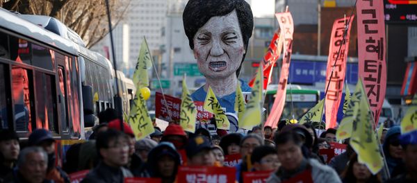 An effigy of South Korean President Park Geun-hye is seen behind people marching towards the Presidential Blue House during a protest calling for South Korean President Park Geun-hye to step down in central Seoul, South Korea, December 10, 2016 An effigy of South Korean President Park Geun-hye is seen behind people marching towards the Presidential Blue House during a protest calling for South Korean President Park Geun-hye to step down in central Seoul, South Korea, December 10, 2016 - Sputnik International