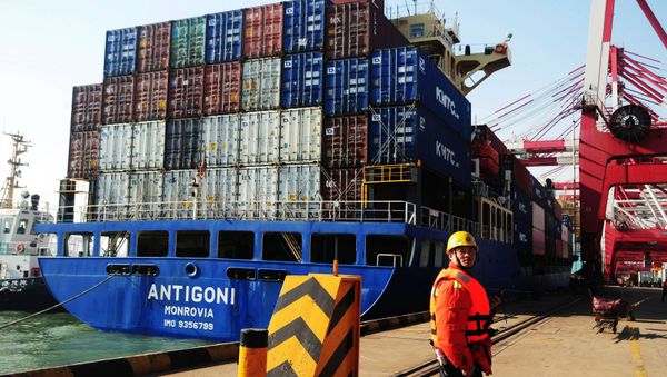 This picture taken on March 7, 2014 shows a man working beside a cargo ship in Qingdao port in Qingdao, east China's Shandong province - Sputnik International