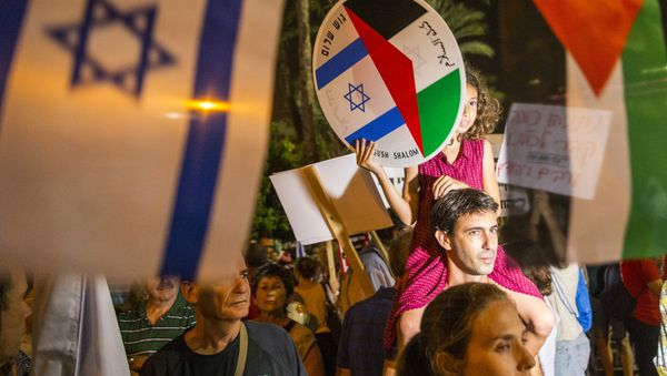 A young girl holds a bearing images of the Israeli and Palestinian flags during a Israeli left-wing activist rally demanding fresh Israeli-Palestinian peace talks, on the eve of the 20th anniversary of the killing of late Israeli prime minister Yitzhak Rabin, at the Rabin Square in the Israeli city of Tel Aviv on October 24, 2015 - Sputnik International