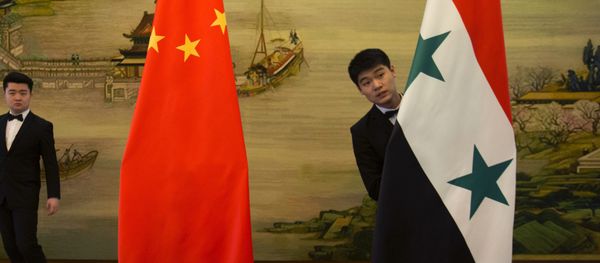 Attendants adjust Syrian and Chinese flags before a briefing at China's Ministry of Foreign Affairs in Beijing, Thursday, Dec. 24, 2015 - Sputnik International