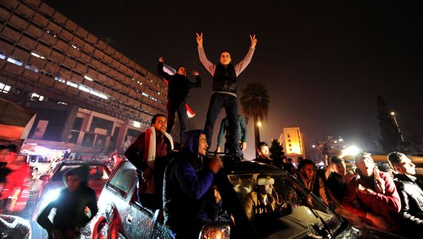 Supporters of Syria's President Bashar al-Assad carry their national flags and gesture as they tour the streets in celebration of what they say is the Syrian army's victory against the rebels in Aleppo, Syria December 12, 2016 - Sputnik International