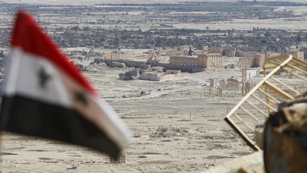 A Syrian national flag flutters as the ruins of the historic city of Palmyra are seen in the background, in Homs Governorate, Syria April 1, 2016. A Syrian national flag flutters as the ruins of the historic city of Palmyra are seen in the background, in Homs Governorate, Syria April 1, 2016. - Sputnik International