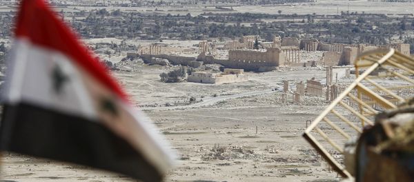 A Syrian national flag flutters as the ruins of the historic city of Palmyra are seen in the background, in Homs Governorate, Syria April 1, 2016. A Syrian national flag flutters as the ruins of the historic city of Palmyra are seen in the background, in Homs Governorate, Syria April 1, 2016. - Sputnik International