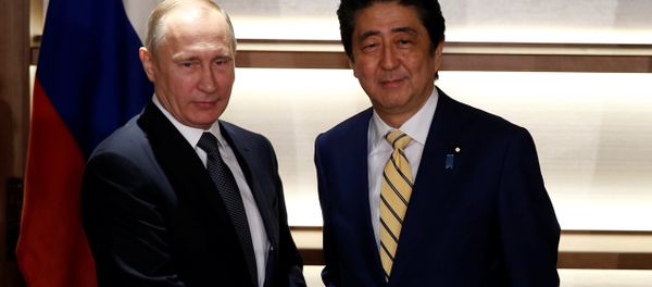 Russia's President Vladimir Putin (L) shakes hands with Japan's Prime Minister Shinzo Abe at the start of their summit meeting in Nagato, Yamaguchi prefecture, Japan, December 15, 2016. - Sputnik International