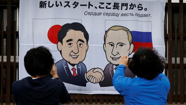 People take photos of a banner showing Japan's Prime Minister Shinzo Abe and Russian President Vladimir Putin at the Senzaki station in Nagato, Yamaguchi prefecture, Japan, December 14, 2016, a day before their summit meeting. The words on top reads, A new start from here in Nagato. People take photos of a banner showing Japan's Prime Minister Shinzo Abe and Russian President Vladimir Putin at the Senzaki station in Nagato, Yamaguchi prefecture, Japan, December 14, 2016, a day before their summit meeting. The words on top reads, A new start from here in Nagato. - Sputnik International