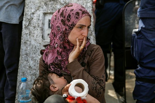 A woman sits with her child after migrants and refugees tried to open the border fence at a makeshift camp at the Greek-Macedonian border near the village of Idomeni, Greece, April 7, 2016. - Sputnik International