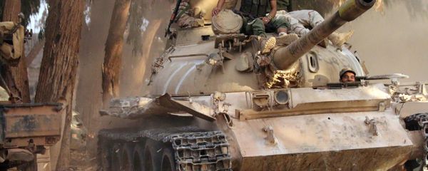 Soldiers from the Libyan National Army, led by Marshal Khalifa Haftar, drive their tank on November 19, 2016 in the Qawarsha sector, 10 kilometres (six miles) west of the centre of Benghazi, after they retook the area from jihadist fighters - Sputnik International