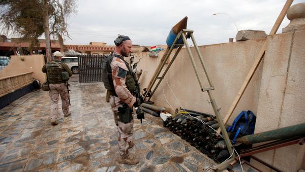 A US soldier looks at weapons and ammunition belonging to Daesh terrorists in the town of Bashiqa, east of Mosul, Iraq, December 14, 2016 - Sputnik International
