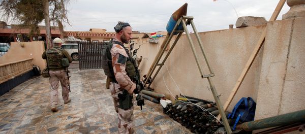 A US soldier looks at weapons and ammunition belonging to Daesh terrorists in the town of Bashiqa, east of Mosul, Iraq, December 14, 2016 - Sputnik International