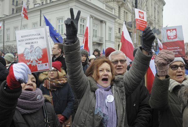 Protesters holding copies of Poland's constitution shout slogans during an anti-government demonstration, in Warsaw, Poland, Saturday, Dec. 17, 2016 - Sputnik International
