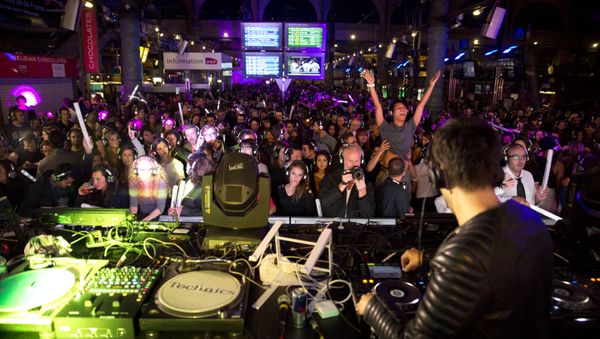 People dance as they listen to music using wireless headphones at a silent disco set up in the Gare du Nord railway station in Paris early on October 4, 2015, during the Nuit Blanche night-time arts festival - Sputnik International