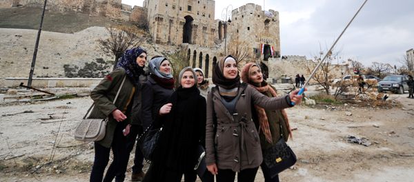 Women take a selfie outside Aleppo's historic citadel, in the government controlled area of the city, Syria December 17, 2016 Women take a selfie outside Aleppo's historic citadel, in the government controlled area of the city, Syria December 17, 2016 - Sputnik International