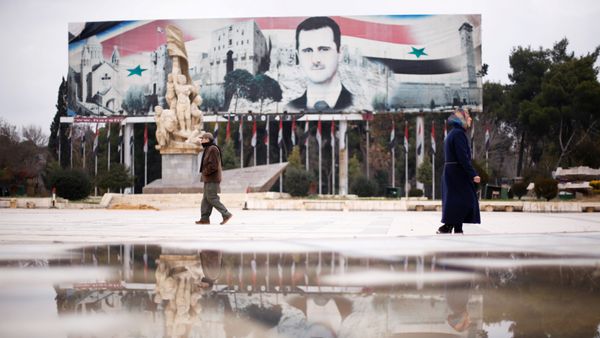 People walk past a billboard depicting Syria's President Bashar al-Assad at Saadallah al-Jabri Square, in the government controlled area of Aleppo, Syria December 17, 2016 - Sputnik International