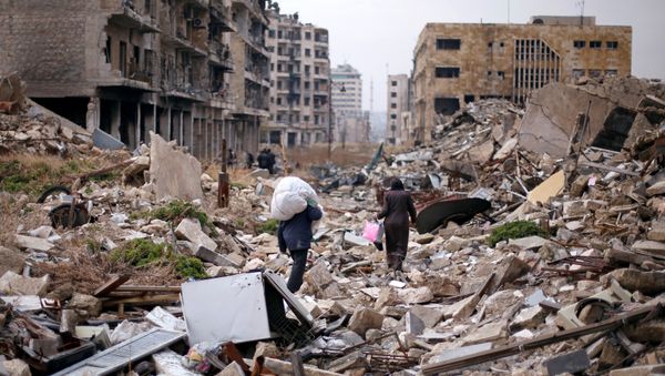 People walk amid the rubble as they carry belongings that they collected from their houses in the government controlled area of Aleppo, Syria December 17, 2016 - Sputnik International
