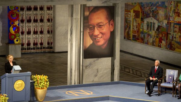 This file photo taken on December 10, 2010 shows Norwegian actress Liv Ullmann (L) reading Liu Xiaobo's text I have no enemies next to the The Nobel Peace Prize committee Chairman Thorbjoern Jagland (R) sitting next to an empty chair during the ceremony for the Nobel Peace Prize Laureate and Chinese dissident Liu Xiaobo (displayed at C) at the city hall in Oslo, on December 10, 2010 - Sputnik International