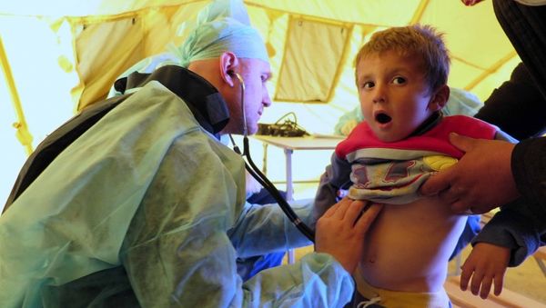 Russian doctor inspects a Syrian boy for signs of respiratory infection - Sputnik International