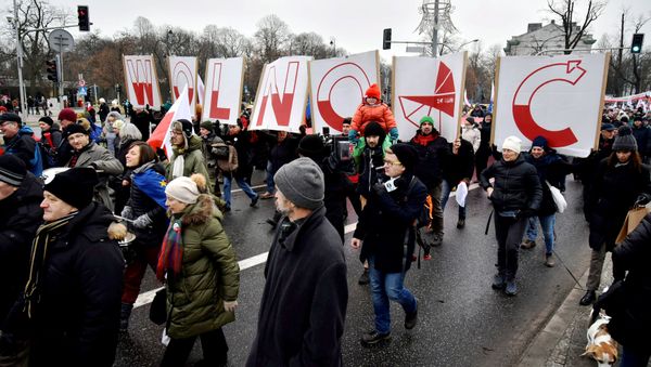 People hold signs of letters composing the word 'Freedom' as they march in an anti-government protest in Warsaw, Poland December 18, 2016. People hold signs of letters composing the word 'Freedom' as they march in an anti-government protest in Warsaw, Poland December 18, 2016. - Sputnik International