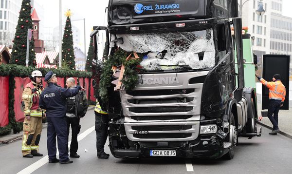 A policeman and firemen stand next to a truck on December 20, 2016 at the scene where it crashed into a Christmas market near the Kaiser-Wilhelm-Gedaechtniskirche (Kaiser Wilhelm Memorial Church) in Berlin - Sputnik International