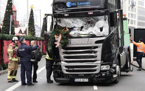 A policeman and firemen stand next to a truck on December 20, 2016 at the scene where it crashed into a Christmas market near the Kaiser-Wilhelm-Gedaechtniskirche (Kaiser Wilhelm Memorial Church) in Berlin - Sputnik International