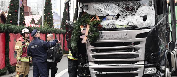 A policeman and firemen stand next to a truck on December 20, 2016 at the scene where it crashed into a Christmas market near the Kaiser-Wilhelm-Gedaechtniskirche (Kaiser Wilhelm Memorial Church) in Berlin A policeman and firemen stand next to a truck on December 20, 2016 at the scene where it crashed into a Christmas market near the Kaiser-Wilhelm-Gedaechtniskirche (Kaiser Wilhelm Memorial Church) in Berlin - Sputnik International