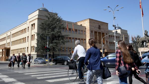 People walk across a street in front of the Parliament building in Macedonia’s capital Skopje, Thursday, April 7, 2016 - Sputnik International