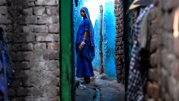 An Indian woman looks on as she stands outside her house in the Kathputli Colony in New Delhi on December 20, 2016 An Indian woman looks on as she stands outside her house in the Kathputli Colony in New Delhi on December 20, 2016 - Sputnik International