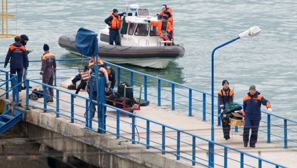 Russian rescuers carry a stretcher with passenger belongings after a Russian military plane crashed in the Black Sea, on a pier outside Sochi - Sputnik International