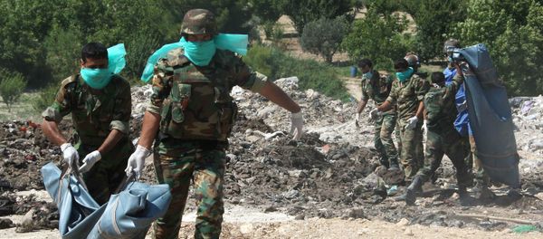 Syrian army troops remove corpses from a  mass grave (File) - Sputnik International