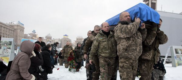 People, including servicemen and civilians, stand and kneel as the Ukrainian soldiers carry the coffin bearing the body of police captain Oleksandr Ilnitsky, who was shot dead by a sniper in the war conflict-hit Donetsk region, during a commemoration ceremony in Independence Square in Kiev, Ukraine, on Monday, Jan. 11, 2016 People, including servicemen and civilians, stand and kneel as the Ukrainian soldiers carry the coffin bearing the body of police captain Oleksandr Ilnitsky, who was shot dead by a sniper in the war conflict-hit Donetsk region, during a commemoration ceremony in Independence Square in Kiev, Ukraine, on Monday, Jan. 11, 2016 - Sputnik International
