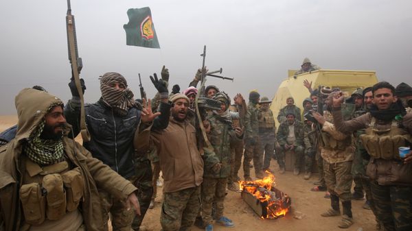 Iraqi Shiite fighters from the Hashed al-Shaabi (Popular Mobilisation) paramilitaries gesture to the camera as they warm up around a fire near the village of Tal Faris, south of Tal Afar, on November 30, 2016, during a broad offencive by Iraq forces to retake the city Mosul from jihadists of the Islamic State group Iraqi Shiite fighters from the Hashed al-Shaabi (Popular Mobilisation) paramilitaries gesture to the camera as they warm up around a fire near the village of Tal Faris, south of Tal Afar, on November 30, 2016, during a broad offencive by Iraq forces to retake the city Mosul from jihadists of the Islamic State group - Sputnik International