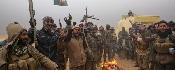 Iraqi Shiite fighters from the Hashed al-Shaabi (Popular Mobilisation) paramilitaries gesture to the camera as they warm up around a fire near the village of Tal Faris, south of Tal Afar, on November 30, 2016, during a broad offencive by Iraq forces to retake the city Mosul from jihadists of the Islamic State group Iraqi Shiite fighters from the Hashed al-Shaabi (Popular Mobilisation) paramilitaries gesture to the camera as they warm up around a fire near the village of Tal Faris, south of Tal Afar, on November 30, 2016, during a broad offencive by Iraq forces to retake the city Mosul from jihadists of the Islamic State group - Sputnik International