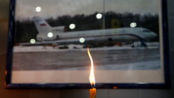 A candle is placed in front of a picture of Tu-154 plane, to commemorate passengers and crew members of Russian military plane, which crashed into the Black Sea on its way to Syria on Sunday, at the Sochi International Airport (Sochi-Adler Airport) in the Black Sea resort city of Sochi, Russia, December 26, 2016 - Sputnik International