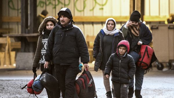 Migrants walk in a refugee camp in Grande-Synthe, northern France. (File) - Sputnik International