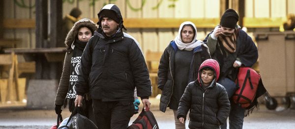 Migrants walk in a refugee camp on December 14, 2016 in Grande-Synthe, northern France - Sputnik International