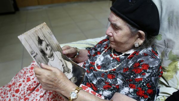 Frecha Amar, 84, from a Moroccan descent, poses with a picture of her baby, who she says was abducted in 1958, on June 29, 2016 at her home in Kfar Chabad, near Tel-Aviv - Sputnik International